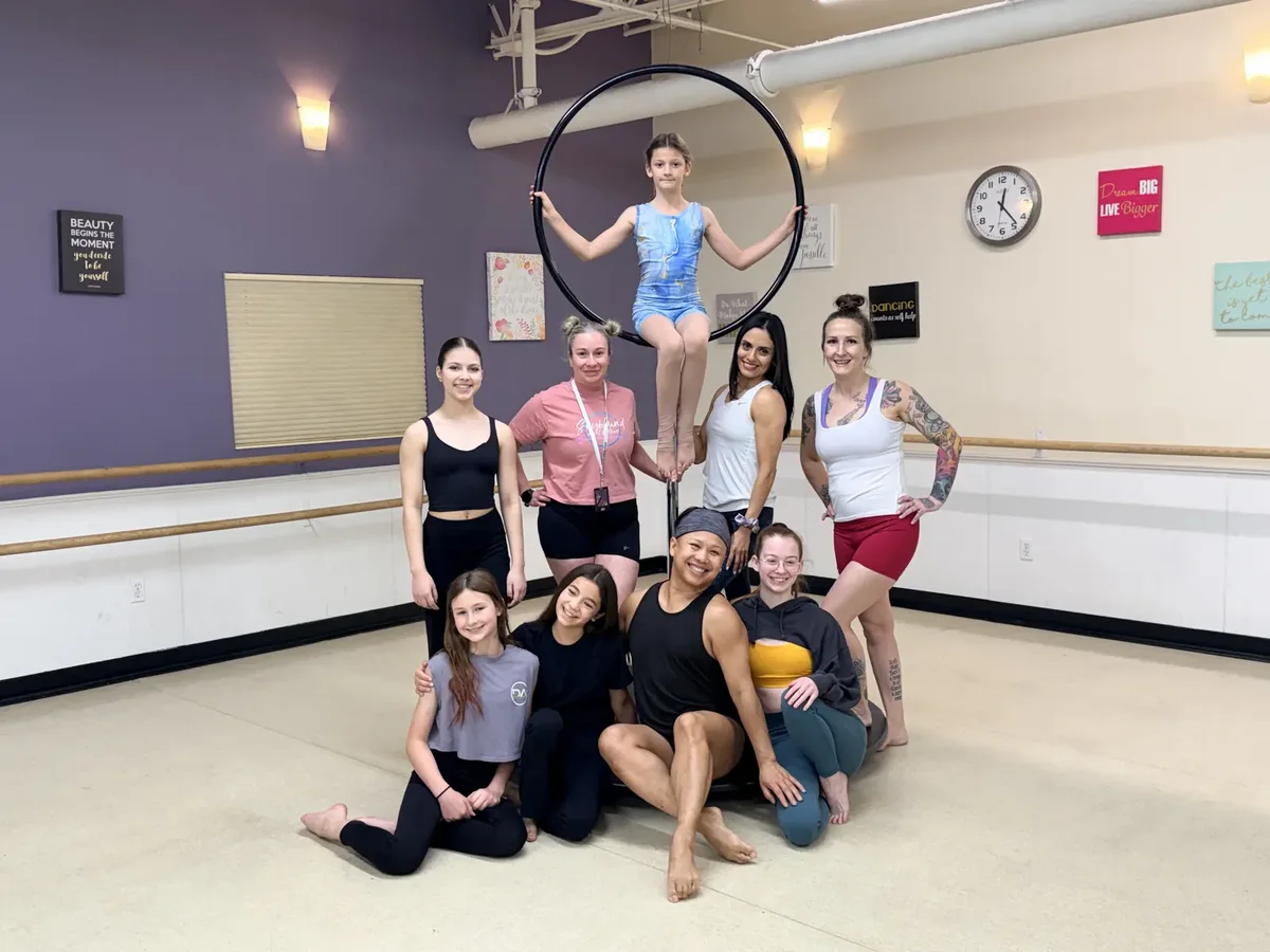 Starbound students gathered around a lyra hoop for a group photo