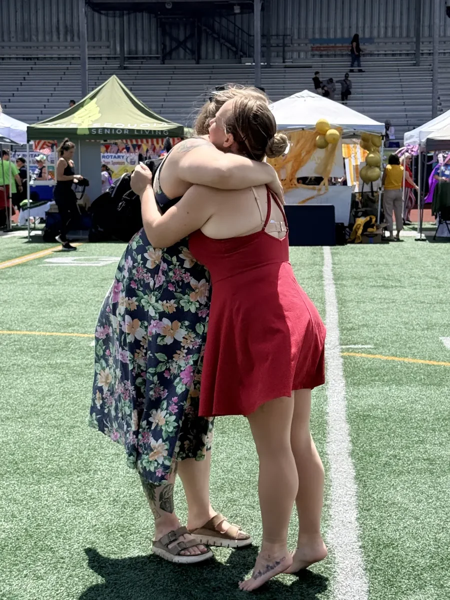Two Starbound members hugging at an outdoor community event