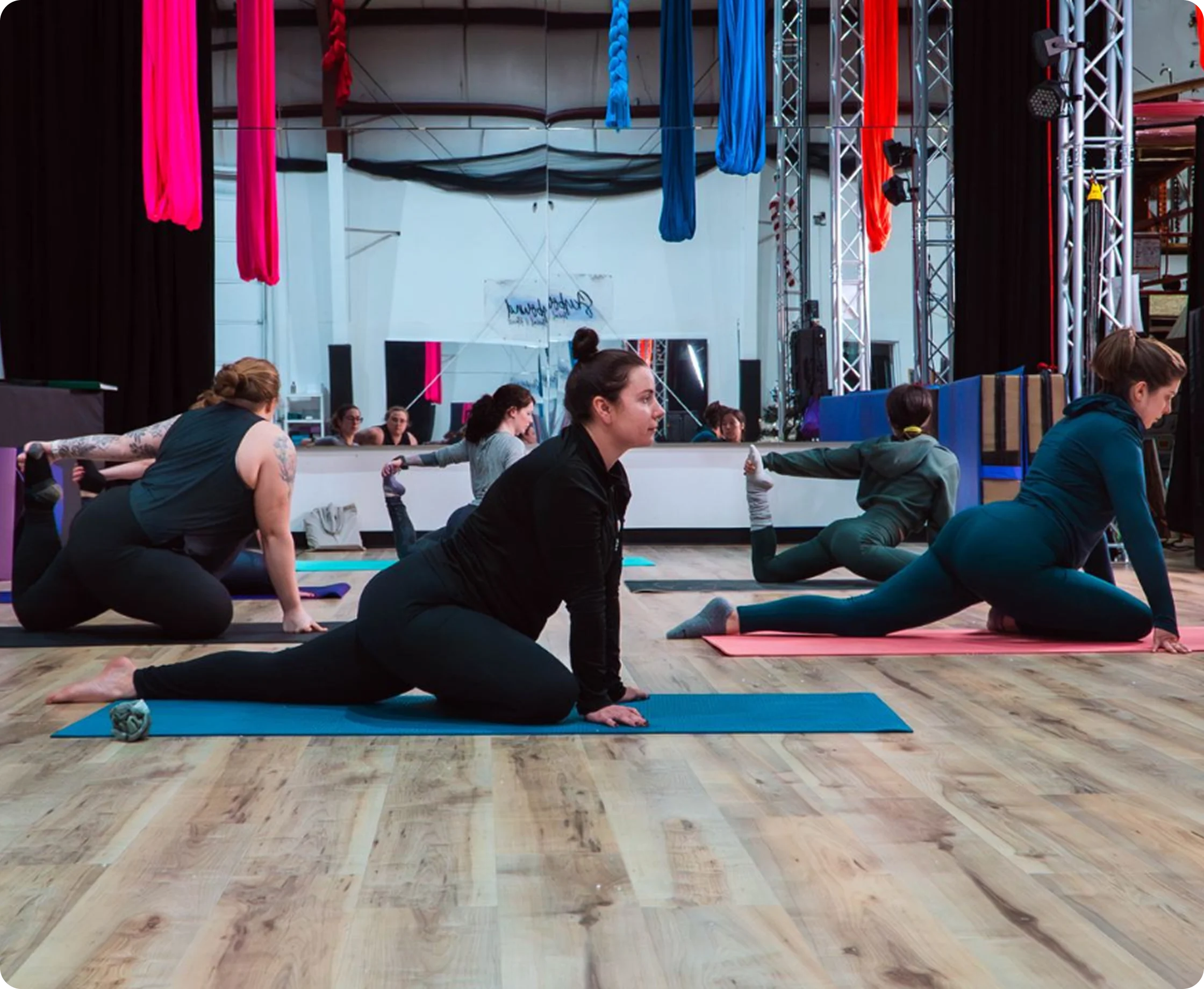 Students stretching on yoga mats during a flexibility class